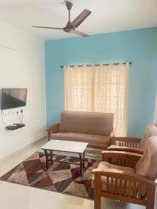a living room with a couch and a table at HK villas in Edappally