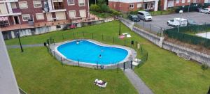 an empty swimming pool in a grassy area with cars at Apartamento Mar in Bádames