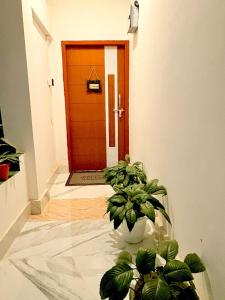 a red door with plants in front of it at Vasudha Homestay in Sibsāgar +3 photos