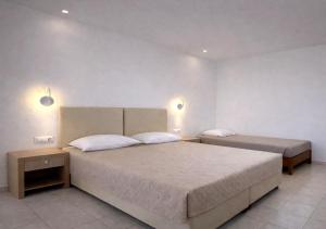 a bedroom with two beds and two lights on the wall at Golden Sun in Tigaki +50 photos