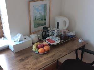 a wooden table with a plate of fruit on it at Ardnacassa in Kilcrohane