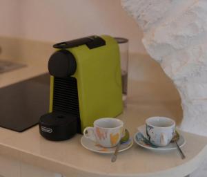 a coffee maker and two cups on a counter at Arcobaleno in Locorotondo +7 photos