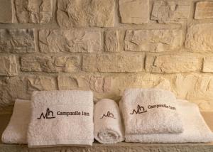 two towels sitting on a table next to a stone wall at Arcobaleno in Locorotondo