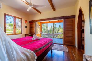 a bedroom with a bed with a red bedspread at La Perla del Caribe - Villa Opal in San Pedro +50 photos