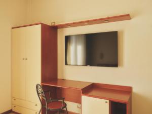 a room with a tv and a desk and a chair at Hotel Palazzo dei Priori in Siena
