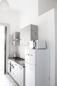 a kitchen with white cabinets and a white refrigerator at Villa Iside Casavacanze in Gragnano