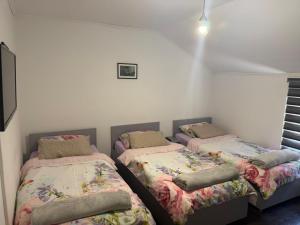 a room with three beds in a room at Hostel FM in Mostar
