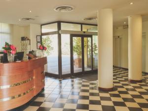 a lobby with a reception counter and columns at Hotel Palazzo dei Priori in Siena