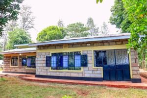 a small brick building with black doors and windows at Asili House in Sagana