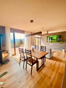ein Esszimmer mit einem Holztisch und Stühlen in der Unterkunft HighLand 伊豆大島箱根連峰を望む高級貸切ヴィラサウナ大型ウッドデッキ薪ストーブ完備 in Arashi