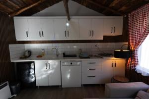 a kitchen with white cabinets and a sink at Eymirbungalovya in Yeşilkent