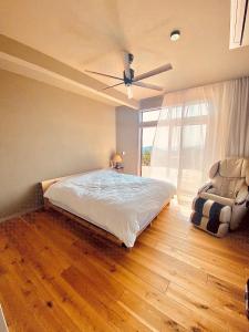 ein Schlafzimmer mit Bett und Deckenventilator in der Unterkunft HighLand 伊豆大島箱根連峰を望む高級貸切ヴィラサウナ大型ウッドデッキ薪ストーブ完備 in Arashi + 26 Fotos