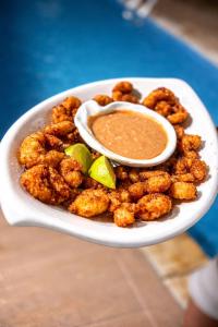 a plate of food with a dipping sauce on it at Pousada Manga Azul in Barra de Camaratuba +85 photos