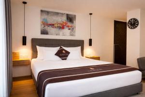 a bedroom with a large white bed and a clock on the wall at stadtwirt bruck in Vöcklabruck +32 photos