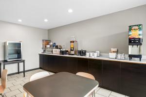a kitchen with a counter and a table and chairs at Super 8 by Wyndham Farmington in Farmington