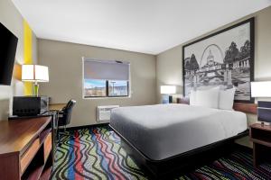 a hotel room with a bed and a desk at Super 8 by Wyndham Farmington in Farmington