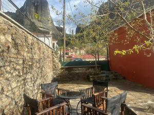 a patio with chairs and a table with a castle in the background at Mikio Guest House in Kalabaka