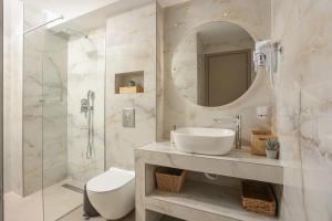 a bathroom with a sink and a toilet and a mirror at Suel Suites Afitos in Afitos +45 photos
