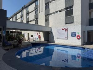 a swimming pool in front of a building at Hotel Las Pergolas in Guadalajara