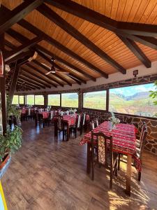 a dining room with tables and chairs with a view at Cazare Conacul Tusinean in Petreştii de Jos