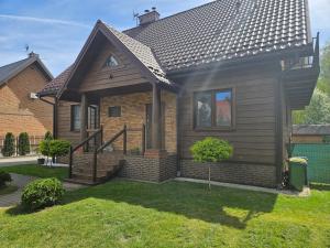 a small house with a roof in a yard at Pokoje U Rycha in Augustów