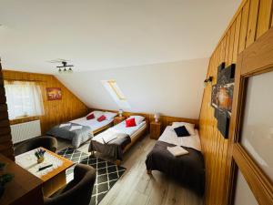 a room with two beds and a table in it at Pokoje U Rycha in Augustów