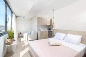 a white room with a bed and a kitchen at Suel Suites Afitos in Afitos