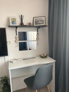 a desk with a mirror and a chair in a room at Refugiul Castelului in Hunedoara