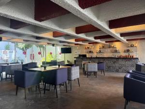 a restaurant with tables and chairs and a bar at Hotel Las Pergolas in Guadalajara
