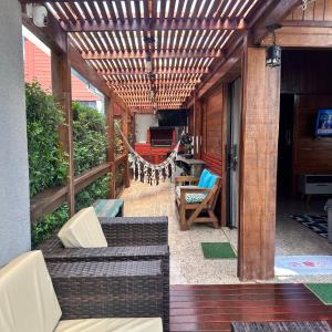 an outdoor patio with a wooden pergola at Chalé com PISCINA Privativa, com 2 QUARTOS, ESTACIONAMENTO em Condomínio com PORTARIA 24h, Sauna, Quadras, 3 PISCINAS no condomínio, Pesca e Parquinho Infantil - SmarTV na sala de estar, TV na área CHURRASQUEIRA, Wi-Fi e Cozinha Completa in Atibaia