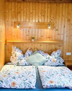 two beds in a room with wooden walls at Pension a apartmány Hanna in Železná Ruda +18 photos