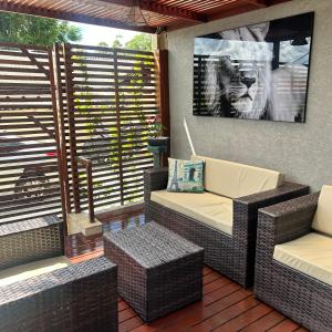a patio with two wicker chairs and a table at Chalé com PISCINA Privativa, com 2 QUARTOS, ESTACIONAMENTO em Condomínio com PORTARIA 24h, Sauna, Quadras, 3 PISCINAS no condomínio, Pesca e Parquinho Infantil - SmarTV na sala de estar, TV na área CHURRASQUEIRA, Wi-Fi e Cozinha Completa in Atibaia