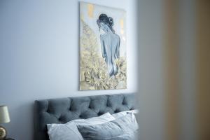 a picture of a woman on the wall above a bed at ApartCieszyn - Apartament Liburnia in Cieszyn