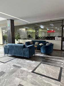 a lobby with blue couches in a building at Hotel Las Pergolas in Guadalajara +73 photos