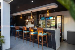 a bar with wooden stools in a restaurant at Aylane Aparth Hotel in Nampula