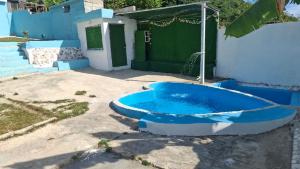a blue tub sitting in a yard next to a house at Villa hotel Gabi Larimar in La Ciénaga
