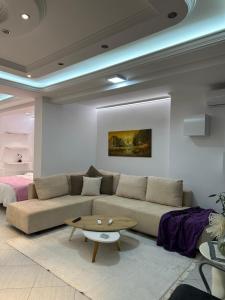 a living room with a couch and a table at Fier Glass Apartament in Fier