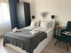 a bedroom with a large bed and a green chair at Refugiul Castelului in Hunedoara