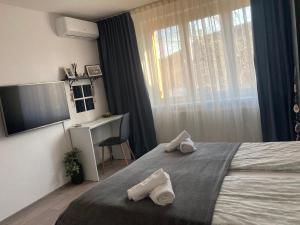 a bedroom with a bed with towels on it at Refugiul Castelului in Hunedoara