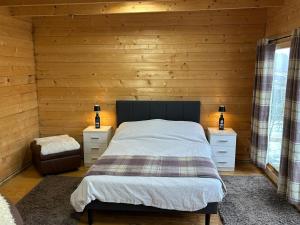 a bedroom with a bed and two night stands at Star Gazer Cabin in Inversnaid