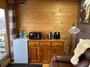 a room with a refrigerator and a microwave on a counter at Star Gazer Cabin in Inversnaid