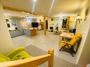 a large living room with yellow furniture and a kitchen at Chata Nova in Milejczyce