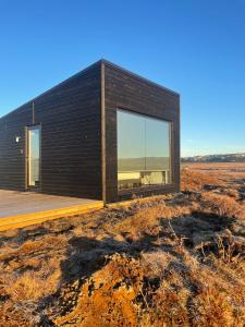 a house with a large window on a field at Golden Circle Panorama Chalet in Selfoss