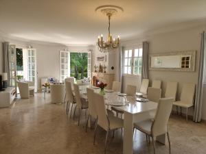 a dining room with a white table and chairs at La Villa des Longchamps Location du samedi au samedi in Saint-Jouan-des-Guérets