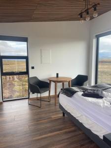 a bedroom with a bed and a table and chairs at Golden Circle Panorama Chalet in Selfoss