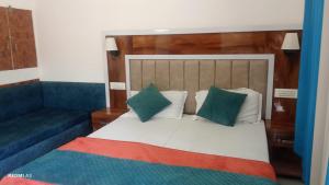 a bedroom with a bed and a blue couch at trigun pahadi hub in Uttarkāshi