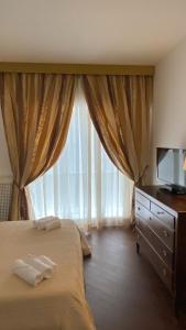 a bedroom with a bed and a large window at Sparano 51 in Bari