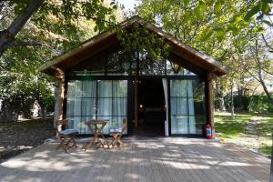 a glass pavilion with two chairs and a table at Eymirbungalovya in Yeşilkent