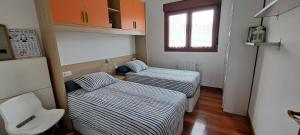 two beds in a small room with a window at Apartamento Mar in Bádames +18 photos