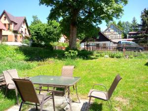 a picnic table and chairs in a yard at Kutloch u Trpoše in Pernink